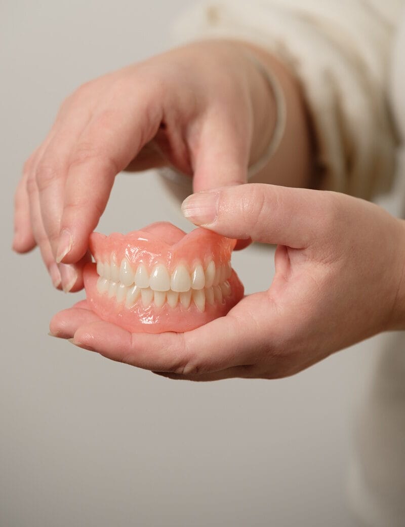 Dentures held in hand